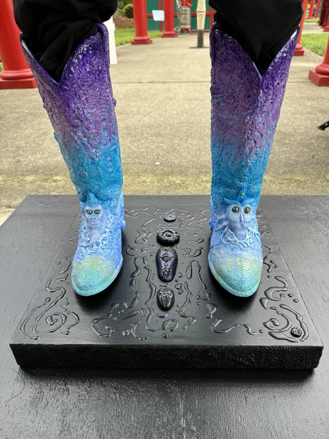 Detail of Big Nat's Hat: the purple-to-turquoise painted boots standing on the carved black base.