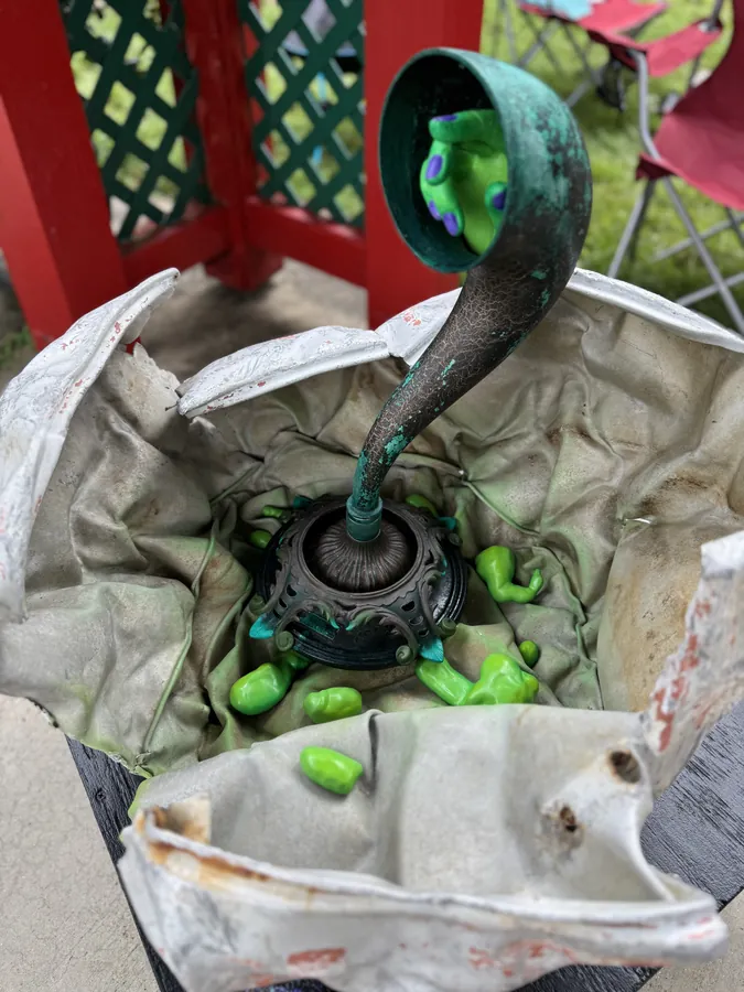Detail of Sputnik Returns: inside the pod, a curving green spout above a ring of bright green forms.