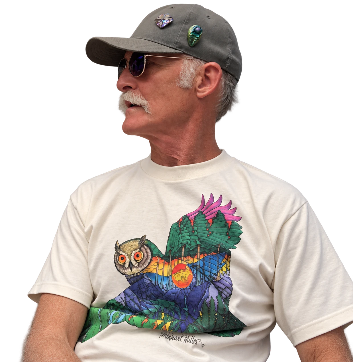 Nathaniel Miller in a cap, sunglasses and an owl T-shirt, looking to the left.