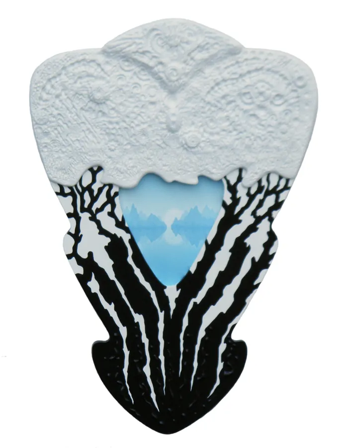 A white carved relief with black tree silhouettes around a pale blue opening.