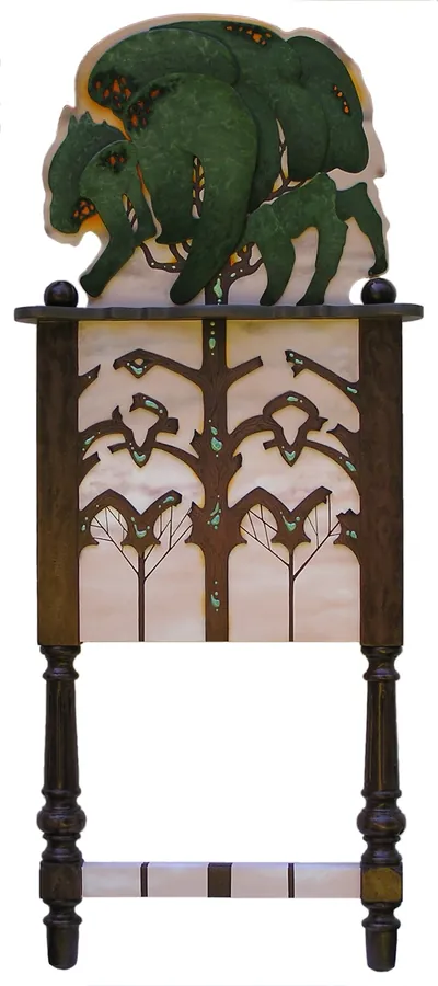 A painted cabinet on turned legs, topped by a carved green bison.