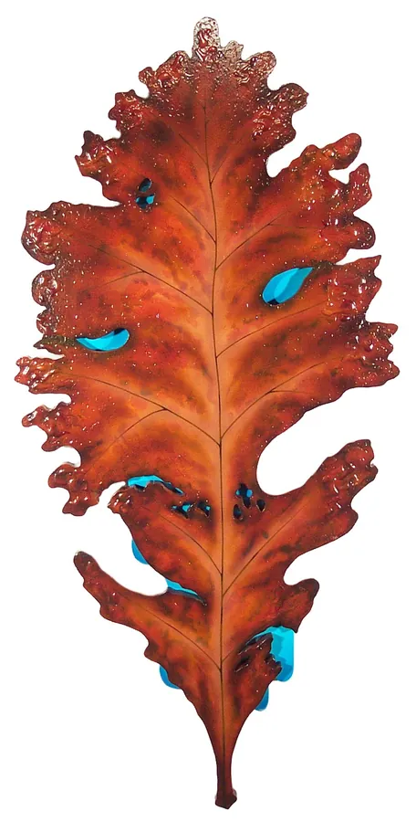 A red-orange oak leaf with turquoise spots, carved in relief.