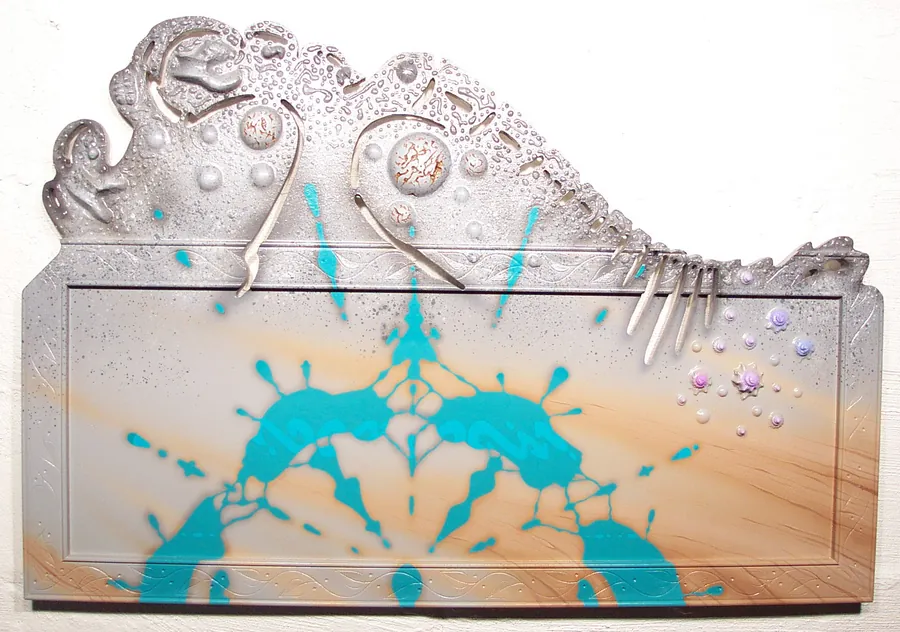 A silver relief panel with curling forms and spoons along its top edge, over a sandy field splashed with turquoise.