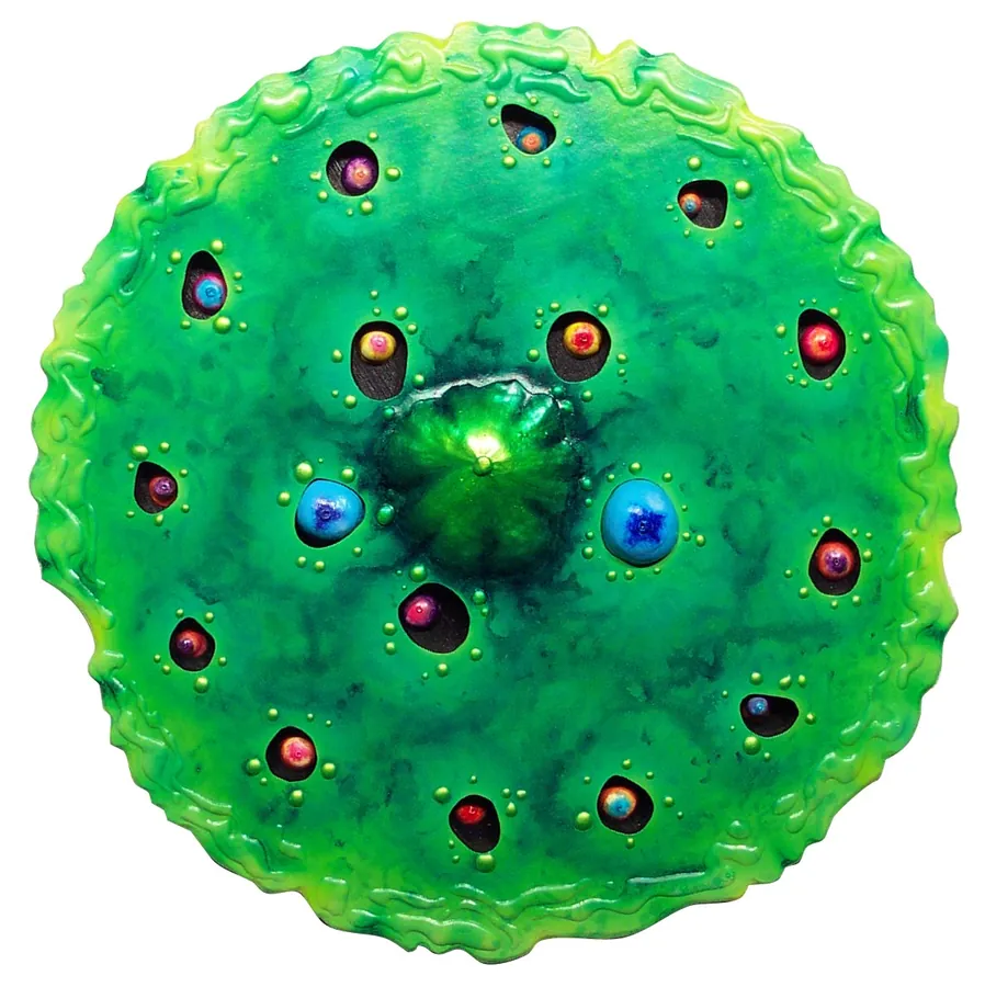 A round green relief studded with colored glass jewels around a green center.